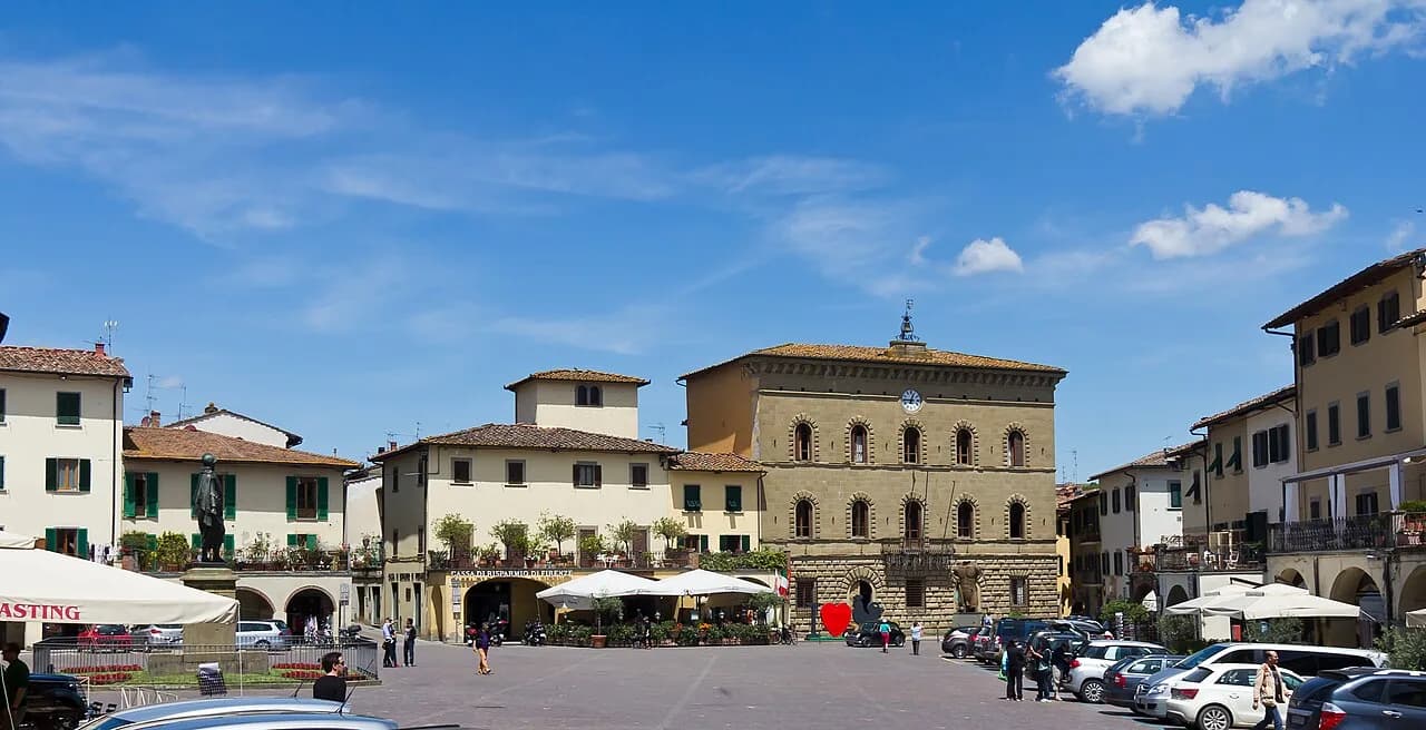 Arcaded buildings, the town hall and parked cars around Piazza Matteotti in Greve in Chianti